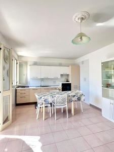 een keuken met een tafel en stoelen erin bij Holiday salento in Leuca