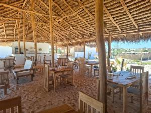 a restaurant with tables and chairs and a view of the ocean at Beheloka Lodge in Ambalaviro +35 photos