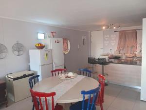 a kitchen with a table and chairs and a refrigerator at Nuovi Inizi in Gansbaai