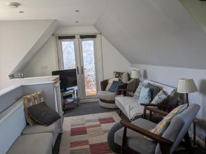 a living room with a couch and a tv at Nest Holiday Home Central Callander, Trossachs Self-catering in Callander