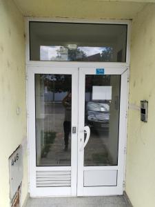 a door with a reflection of a person in the window at Stan na dan MARA in Mladenovac