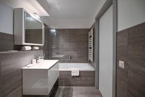 ein Badezimmer mit Waschbecken und Badewanne in der Unterkunft Sunny Suite with lake view in Melide