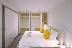 ein Schlafzimmer mit einem weißen Bett und gelben Kissen in der Unterkunft Sunny Suite with lake view in Melide