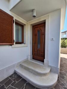 a front door of a house with a wooden door at Apartments Leona in Umag