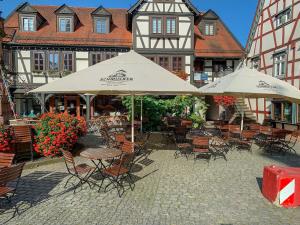 an outdoor patio with tables and chairs and umbrellas at Wohnen am historischen Rathaus in Michelstadt