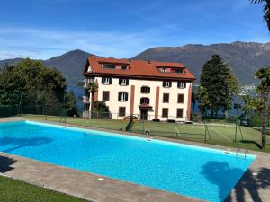a large house with a swimming pool in front of it at Appartement Villa Parco Ameno in Germignaga