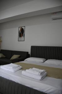 two beds in a room with white towels on them at Apartament Niko shengjin in Lezhë