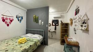 a bedroom with a bed with a yellow towel on it at D'Flora Homestay in Labuan Bajo