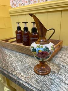 eine Vase mit vier Alkoholflaschen auf einer Theke in der Unterkunft Le cottage du Manoir 1900 in La Ferté-Gaucher + 27 Fotos