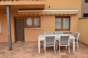 a white table and chairs in front of a building at Cal Espinelves in Olost