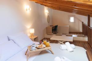 a room with a bed and a table with a tray of food at Chris Luxury Loft in Kallithea Halkidikis