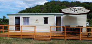 a tiny house with an umbrella on a deck at Domki u Rybaka Wapnica in Wapnica