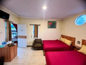 a bedroom with two beds and a chair in it at de Pipo Bromo in Sukapura