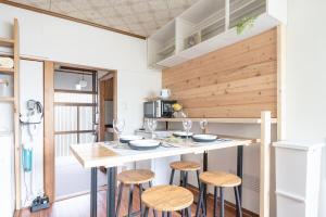 Una cocina con una mesa y taburetes en una habitación. en Komachi two-story house where you can stay as if local, en Wada