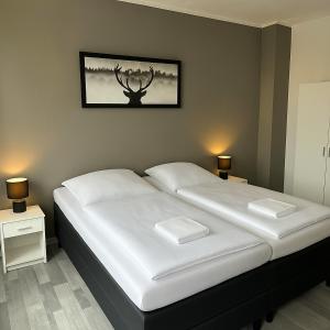 a bedroom with a large bed with a antelope picture on the wall at Apartment Gray Z2 in Erfurt