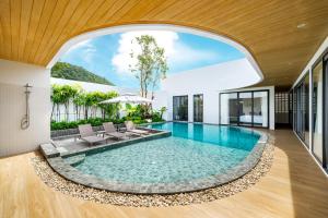 an indoor pool in a house with a large window at MANDLA VILLAS COLLECTION, White Anda Naiharn in Rawai Beach