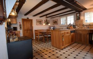 a large kitchen with wooden cabinets and a table at Bed & Breakfast Im Chellhof in Benken