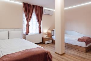 a bedroom with two beds and a window at Къща Инфинити Лукс и Уют, Вплетени в Спомени in Sapareva Banya