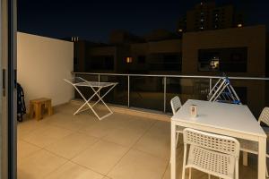 ein weißer Tisch und Stühle auf einem Balkon in der Nacht in der Unterkunft Nice Studio for rent at Jumeirah Village Circle Dubai in Sabkhah