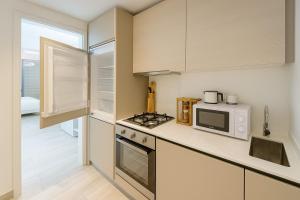 eine Küche mit Herd und Mikrowelle in der Unterkunft Nice Studio for rent at Jumeirah Village Circle Dubai in Sabkhah + 23 Fotos