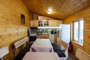 a kitchen with a table and a white refrigerator at Къща Инфинити Лукс и Уют, Вплетени в Спомени in Sapareva Banya