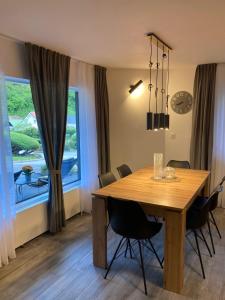 a dining room table with chairs and a large window at Apartment Lida in Podčetrtek