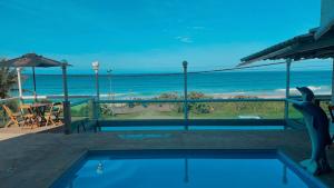 a swimming pool with a view of the ocean at Hotel Aconchego Da Vila in Saquarema
