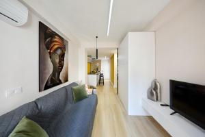 un salon avec un canapé bleu et une télévision à écran plat dans l'établissement Apartamento familiar Puerto Nova en Tierno Galvan, à Carthagène