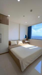 a large bed in a bedroom with a large window at Joie Apartment Hue in Thôn Văn Dương +12 photos