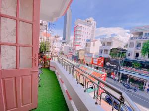 a balcony with a red door and green grass at Happy House Homestay in Hue +37 photos