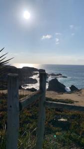 a fence on the beach with the ocean in the background at 4Sea House in Porto Covo +56 photos