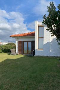 a small white house with a lawn in front of it at 4Sea House in Porto Covo