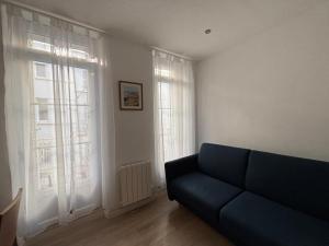 salon z niebieską kanapą i oknami w obiekcie Studio plages du Mourillon w mieście Tulon +3 zdjęcia