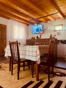 a kitchen and dining room with a table and chairs at Cabana Livada Merilor in Băile Govora