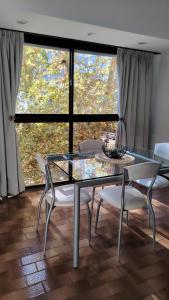 a dining room with a glass table and chairs at Luminoso Ambiente, con cochera en lo mejor de La Perla in Mar del Plata
