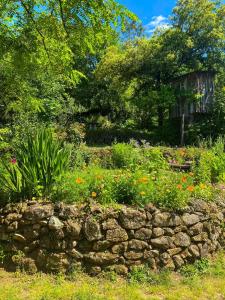 a garden with a stone wall and flowers at Dortoir dans la nature in Chambonas