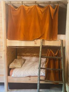 a bunk bed with a curtain on top of it at Dortoir dans la nature in Chambonas