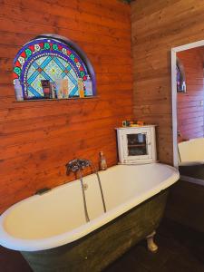 a bath tub in a room with a stained glass window at Dortoir dans la nature in Chambonas