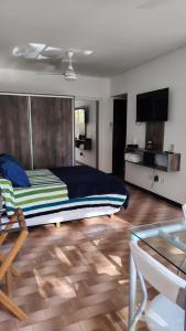 a bedroom with a bed and a tv and a table at Luminoso Ambiente, con cochera en lo mejor de La Perla in Mar del Plata