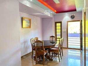 a dining room with a table and chairs at Ammukutty's Cottage in Munnar