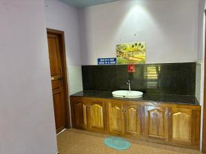 a bathroom with a sink and a black counter top at Ammukutty's Cottage in Munnar