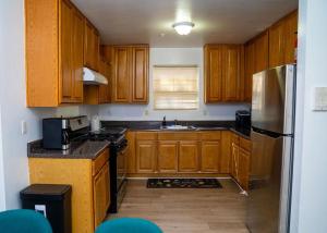 a kitchen with wooden cabinets and a stainless steel refrigerator at Anike's Place in Newark +13 photos
