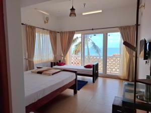 a bedroom with two beds and a view of the ocean at Seaside Homestay in Trivandrum