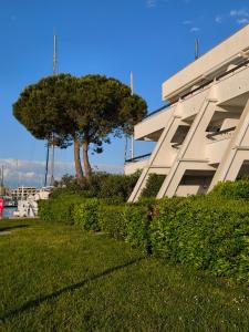 ein Gebäude mit einem Baum vor einem Gebäude in der Unterkunft Adoya plage Studio cabine vue port et mer in Le Grau-du-Roi