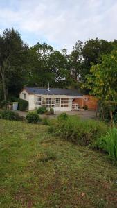 a house in a yard with a grass yard at Pink Granite Coast Cottage between forest and sea in Trélévern