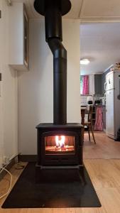 a fireplace in a living room with a fire in it at Pink Granite Coast Cottage between forest and sea in Trélévern