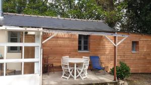 a patio with a table and chairs in front of a house at Pink Granite Coast Cottage between forest and sea in Trélévern +17 photos