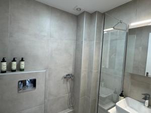 a bathroom with a shower and a sink at Aelia Blu 2 Maisonette in Ofrínion