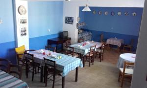 a dining room with tables and chairs and blue walls at Nikos Hotel in Diafani +62 photos