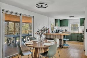 a kitchen with green cabinets and a table and chairs at Charming Retreat Walking in Tannersville